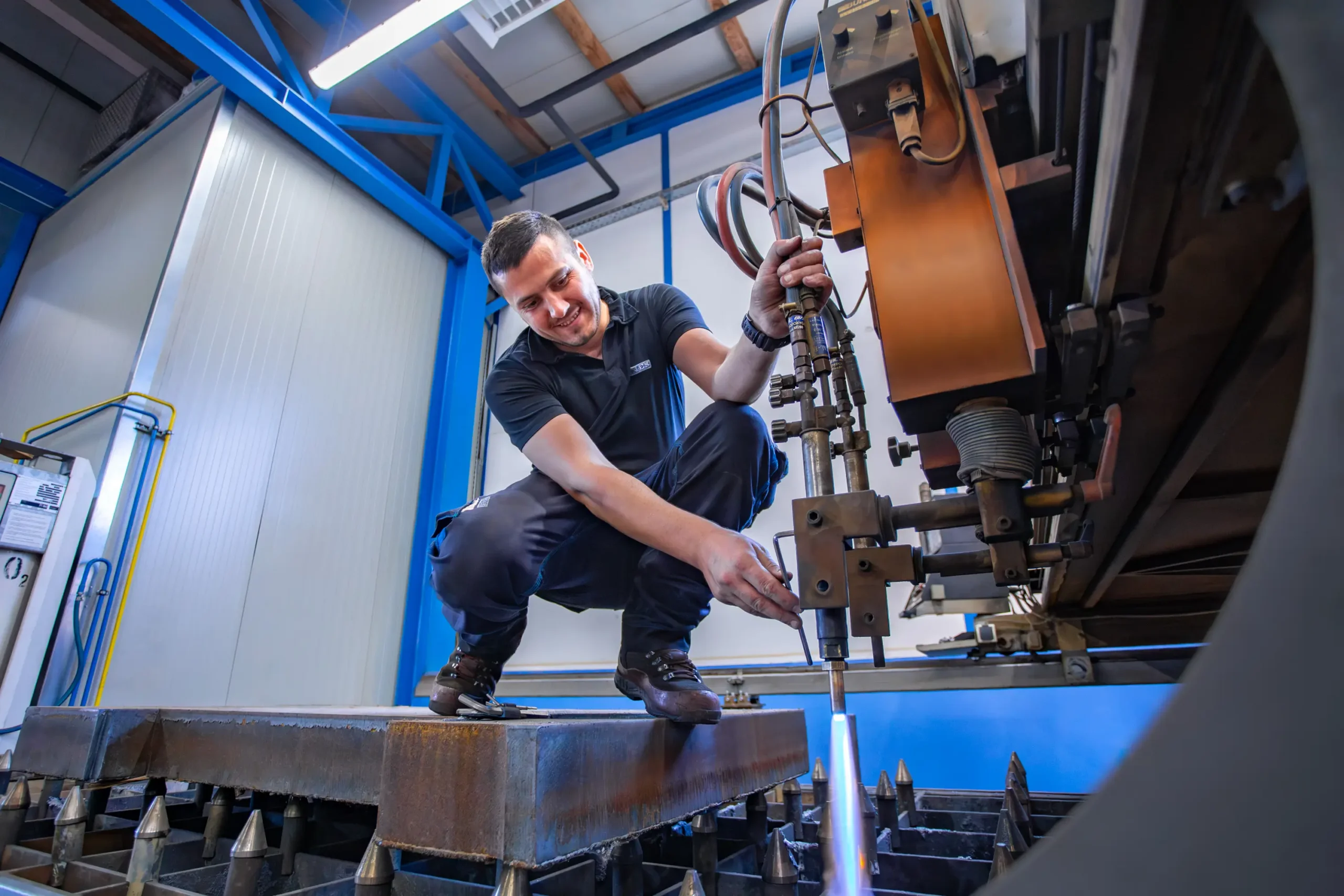 Delavec nastavlja industrijski stroj za plamenski razrez kovinskih plošč