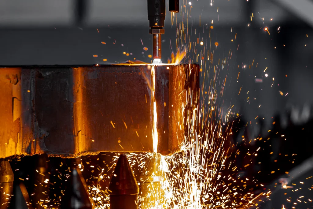 Plamenski razrez debele kovinske plošče v industrijski proizvodnji.