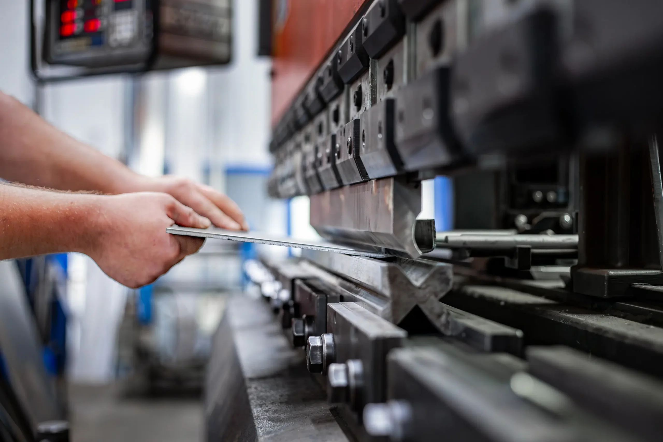 Krivljenje kovinske pločevine s pomočjo stroja za preoblikovanje v delavnici.