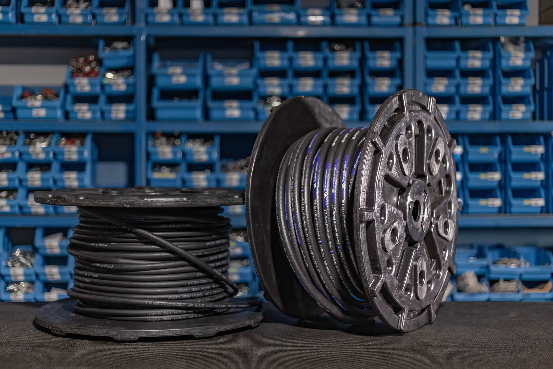 Koluta z navito hidravlično cevjo iz črnega materiala, pripravljena za rezanje na dolžino.