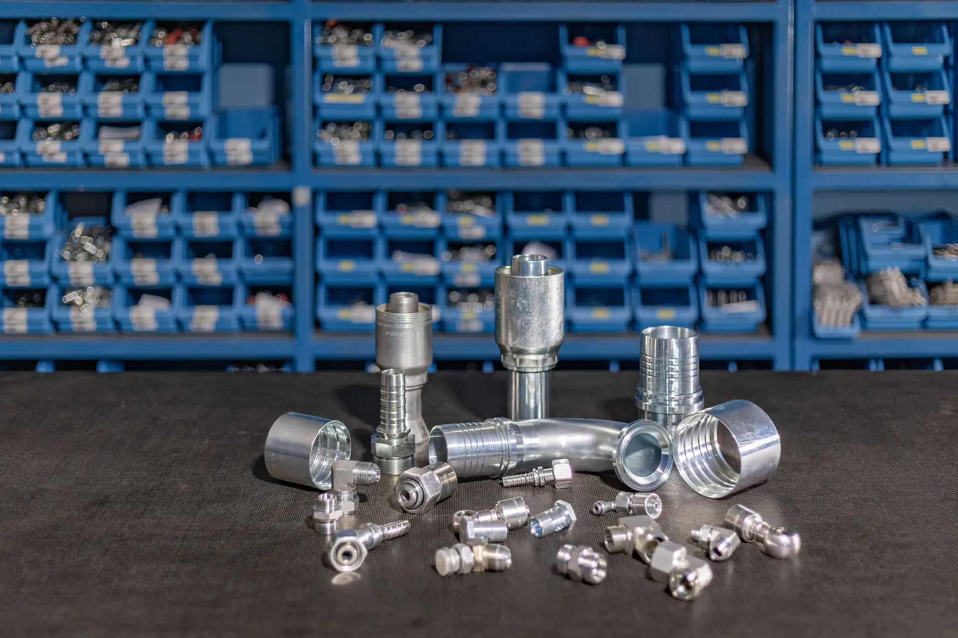 Kovinski hidravlični priključki in spojke različnih velikosti pripravljeni za montažo.