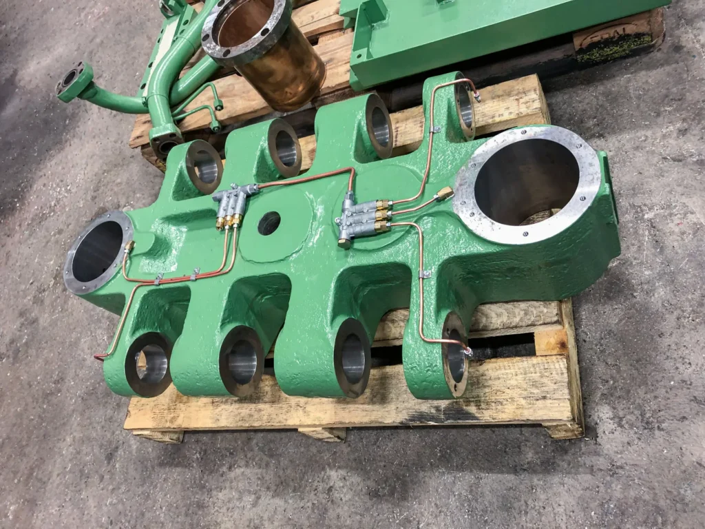 Masivni kovinski element z odprtinami in cevnim sistemom za tlačni liv aluminija.